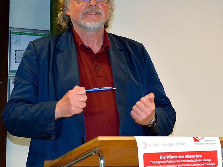 Auf diesem Bild sieht man den Redner Heiner Bielefeld am Rednerpult vortragen.