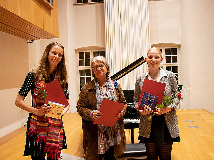 Ein Gruppenbild mit den Preisträgerinnen des Genderpreis Es sind drei Frauen mit Urkunden und Präsenten zu sehen.
